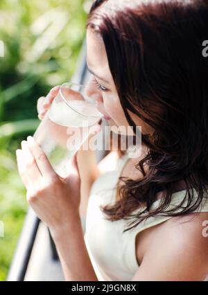 Woman Drinking Water at Six Senses Spa, Heritance Kandalama Hotel, Dambulla, Sri Lanka. A woman drinks a glass of mineral water at the Six Senses Spa. Stock Photo