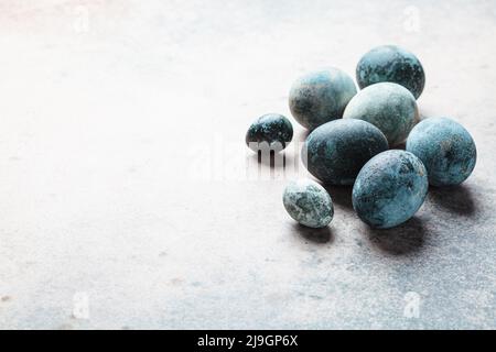 Easter eggs painted in trendy denim blue, copy space, gray background. Stock Photo