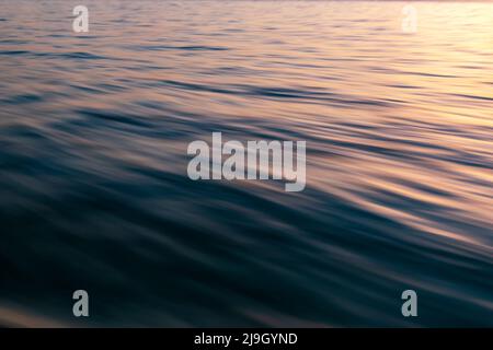 Motion blur of ocean wave with sunrise light Stock Photo