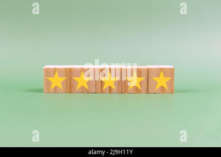 5 star rating on wood block on green background Stock Photo