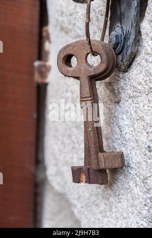 Antique iron keys hung on a granite wall Stock Photo