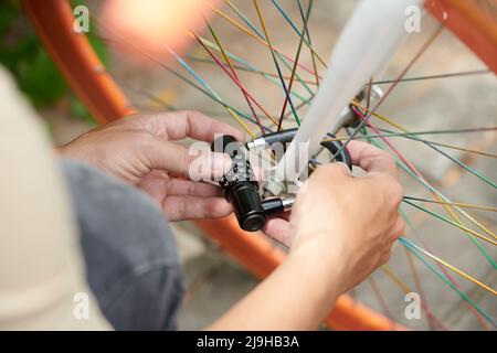 Close-up image of person closing combination lock on bicycle wheel to protect from theft Stock Photo