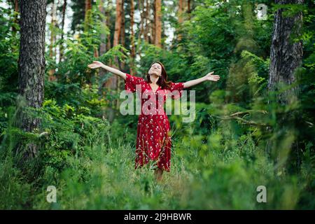 Connecting with nature benefits mental health. Nature Therapy Ecotherapy Helps Mental Health. Nature Impact Wellbeing. Woman in red dress enjoying Stock Photo