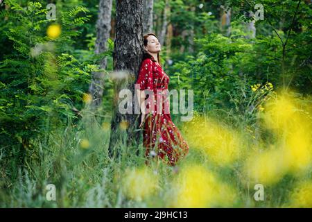 Connecting with nature benefits mental health. Nature Therapy Ecotherapy Helps Mental Health. Nature Impact Wellbeing. Woman in red dress enjoying Stock Photo