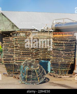 Crab fishing cages on a kay in a harbour. Colorful crab traps are stacked and ready for use. Street photo, nobody, selective focus Stock Photo