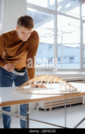 Architect holding virtual reality simulator examining leaf shaped model in office Stock Photo