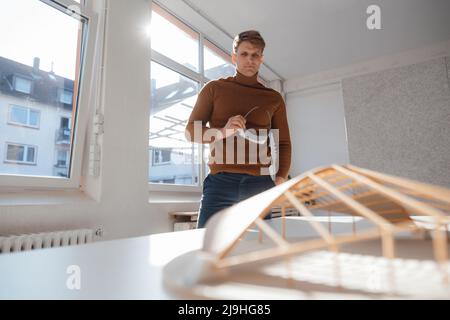 Architect holding virtual reality simulator looking at leaf shaped model in office Stock Photo