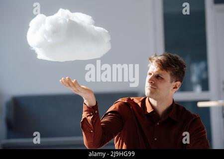 Businessman with levitating cloud network in office Stock Photo