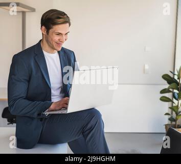 Businessman using laptop in office Stock Photo