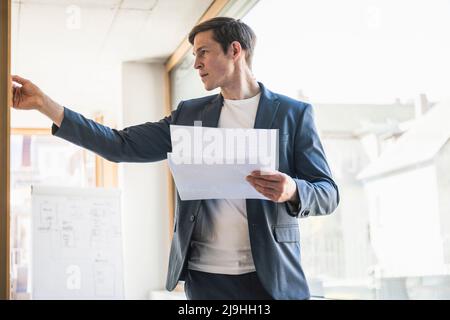 Businessman holding documents working on strategy in office Stock Photo