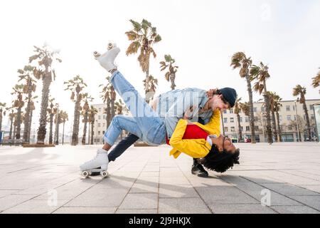 Happy woman wearing roller skate dancing with man on footpath Stock Photo