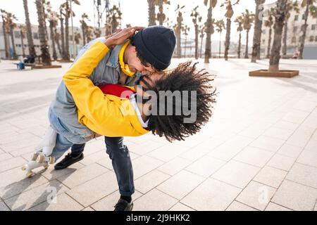 Happy man with woman dancing on footpath Stock Photo