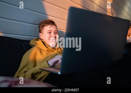Smiling boy using laptop at home Stock Photo