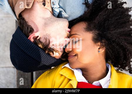 Man with eyes closed kissing girlfriend on forehead Stock Photo