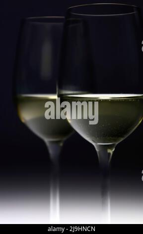 White wine glasses against black background Stock Photo