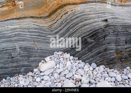 Pebble stones on eroded sandstone at Silence beach Stock Photo