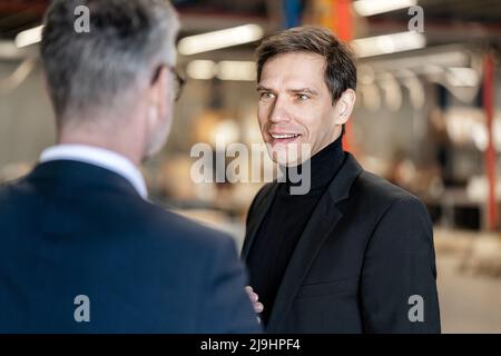 Mature businessman discussing with colleague in warehouse Stock Photo