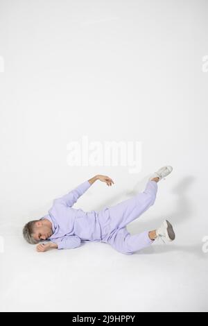 Young man lying on white floor Stock Photo