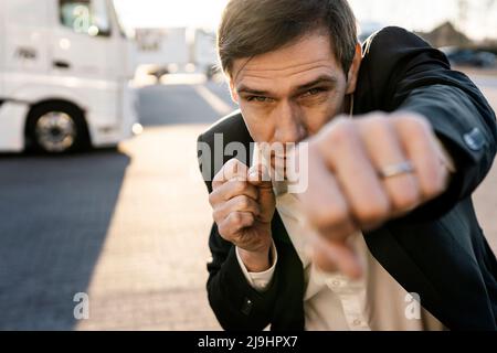 Mature businessman practicing boxing on footpath Stock Photo