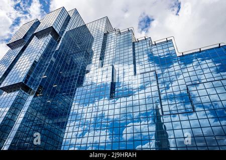 Looking up at The Northern Shell Building on the Northbank in London as The Shard reflects in the blue tinted glass from the Southbank in May 2022. Stock Photo