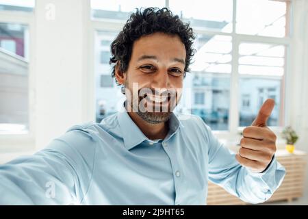 Happy businessman gesturing thumbs up Stock Photo