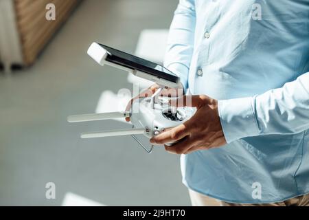 Hands of businessman using drone remote control with smart phone in office Stock Photo