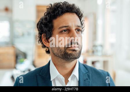 Thoughtful businessman standing in office Stock Photo