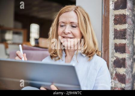 Smiling businesswoman using tablet PC Stock Photo