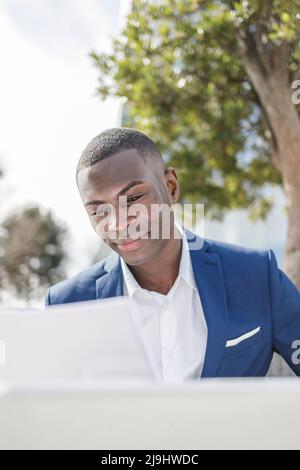 Smiling businessman analyzing document on sunny day Stock Photo