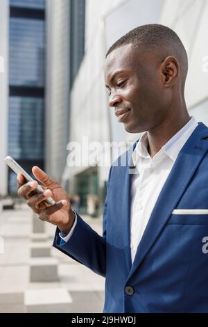 Smiling businessman looking at smart phone Stock Photo