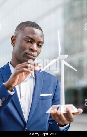 Young engineer examining wind turbine model Stock Photo