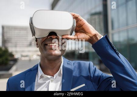 Happy businessman wearing virtual reality simulator Stock Photo