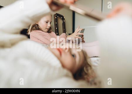Girls using smart phones in bedroom at home Stock Photo