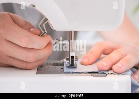 A man sews clothes on a sewing machine. Hobbies, needlework, creativity. Stock Photo