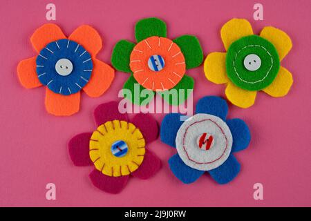 Handmade cute colorful flowers with buttons on pink background Stock Photo