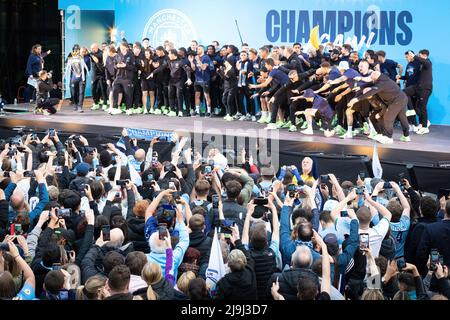 Manchester, UK. 23rd May, 2022. The Manchester City team celebrate winning their forth Premier League title in five years with a parade through the city. Thousands of fans lined the streets to welcome Guardiola and the squad as they travelled through the city showing off the latest trophy. Credit: SOPA Images Limited/Alamy Live News Stock Photo