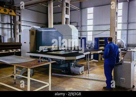 CNC punching and perforation machine and perforated steel sheet. Stock Photo
