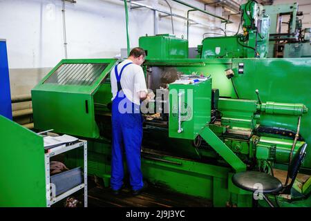 Factory worker working on the lathe. Stock Photo