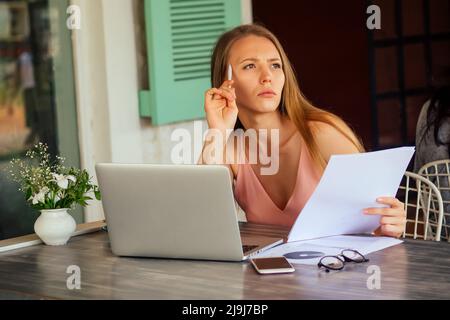 successful young woman chatting on the phone during her lunch break.Candid image of a businesswoman talking on the phone in a summer outdoors cafe Stock Photo