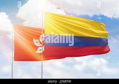 Sunny blue sky and flags of colombia and hong kong Stock Photo