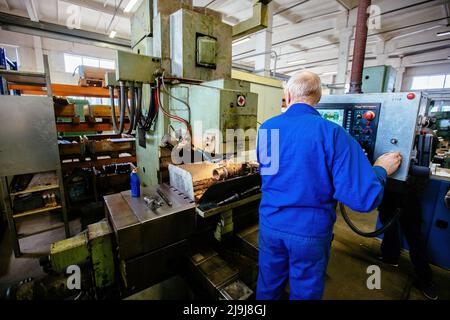 Factory engineer working on CNC lathe machine. Stock Photo