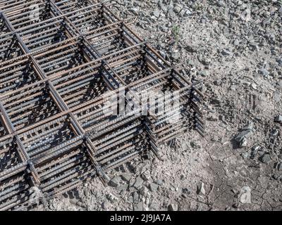 welded reinforcing mesh for the load-bearing frame of a building or a monolithic panel lies on the ground, selective focus Stock Photo