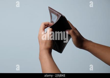 hand holding empty wallet isolated in white background Stock Photo