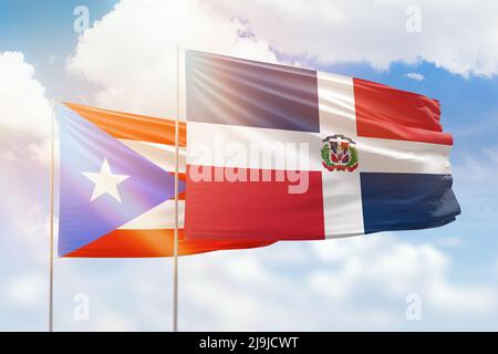 Sunny blue sky and flags of dominican republic and puerto rico Stock Photo