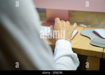 Woman's hand typing on keyboard. Selective focus, close up view. Stock Photo