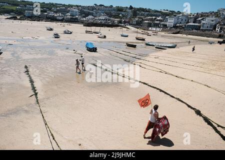 St Ives, UK. 13th June, 2021. An activist of Extinction Rebellion walks along the beach during the 'All Hands On Deck' day of action on the final day of the G7 summit in St Ives, Cornwall. The theme is a reference to Extinction Rebellion's third demand for a Citizens' Assembly on ecological and climate justice to move beyond broken parliamentary democracy and place power in the hands of citizens. (Credit Image: © Joe M O'Brien/SOPA Images via ZUMA Press Wire) Stock Photo