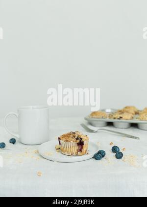 Blueberry muffins on a marble background with cooking utensils and fresh blueberries scattered around it. Food photography flat lay Stock Photo