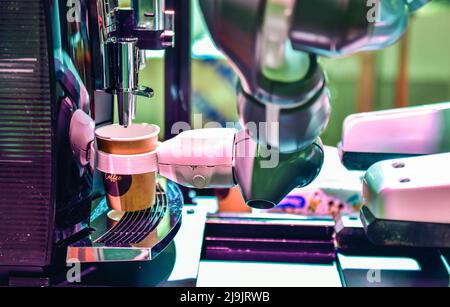 Automatic technology in beverage shop, artificial intelligence, robotic arm serving in coffee shop. Stock Photo
