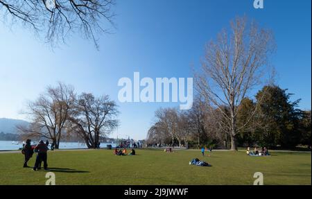 Zurich, Switzerland - March 5th 2022: People relaxing in a park at the lake. Stock Photo