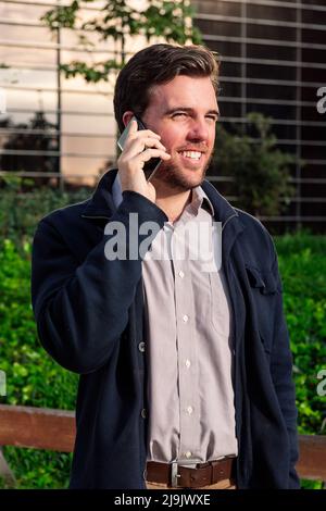 man talking by phone next to an office building Stock Photo